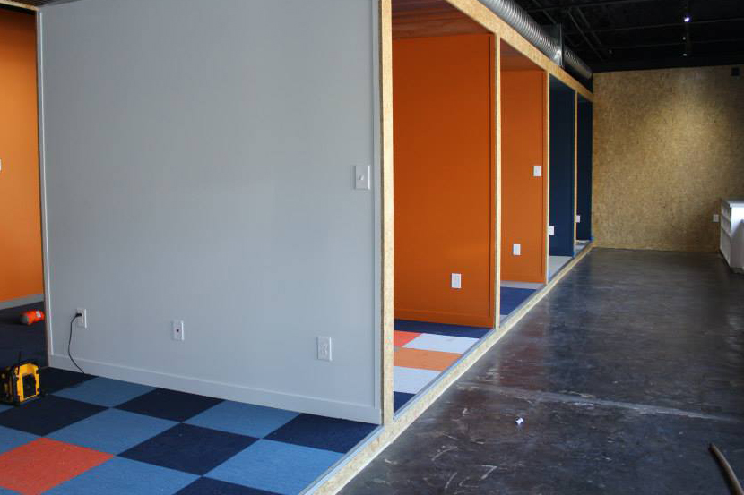 Interior of an office building with blocked off cubicles decorated with orange and blue.