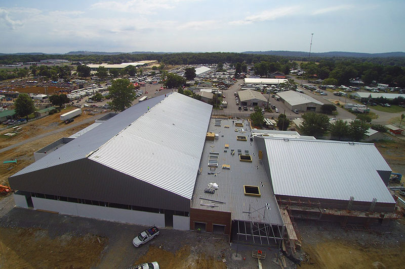 Drone footage of a gray metal building from above.