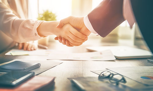 Man and woman are shaking hands in office. Collaborative teamwork.