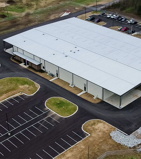 Drone footage of a white metal building from above.
