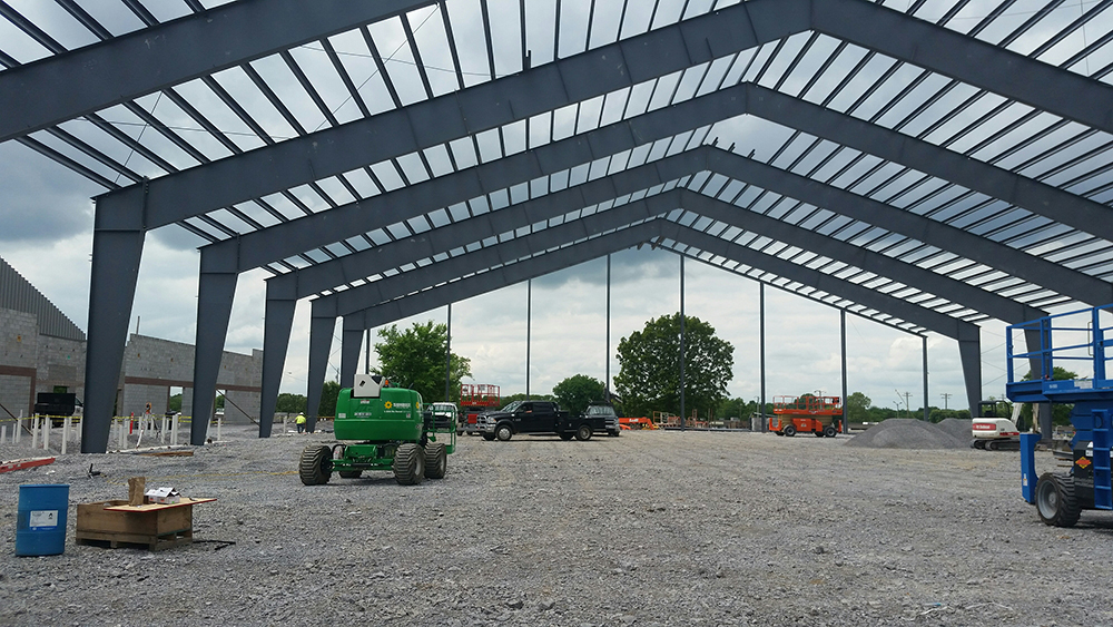 The interior of an empty metal building during its construction.