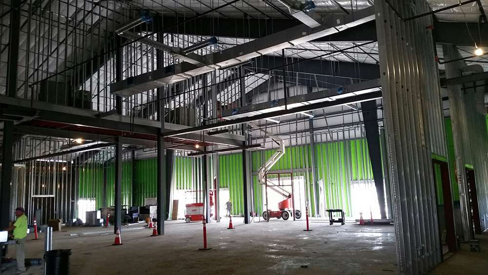 The interior of an empty metal building during its construction.