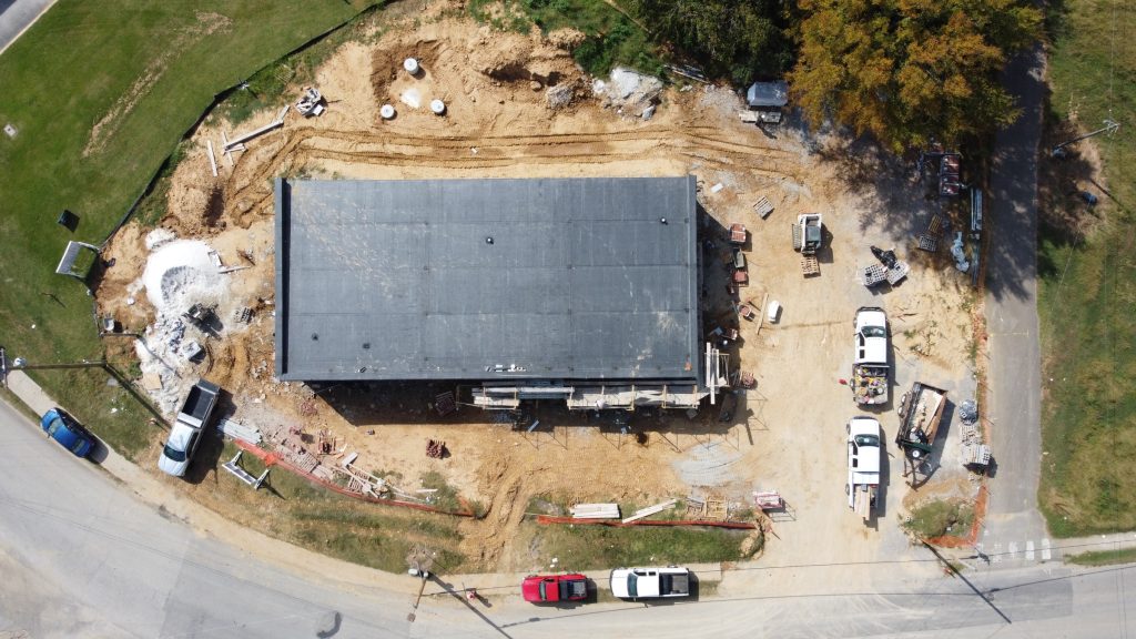 Drone footage of the new Chester County 911 building under construction. Some trees can be seen on the upper right corner and construction trucks can be seen on the left side, right side, and middle.