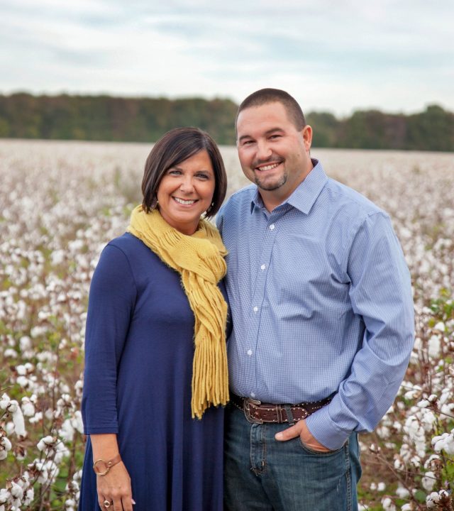 Edward and Tiffany Jones standing in a cotton field and smiling at the camera